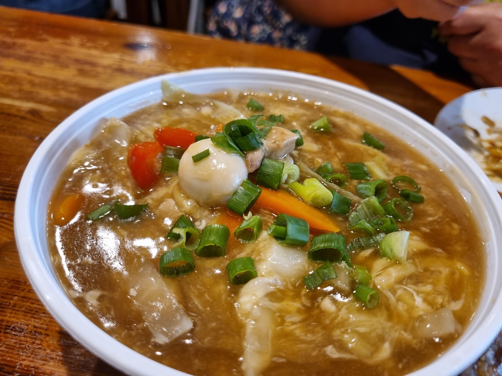 Thick pancit lomi noodle soup topped with quail egg and spring onion