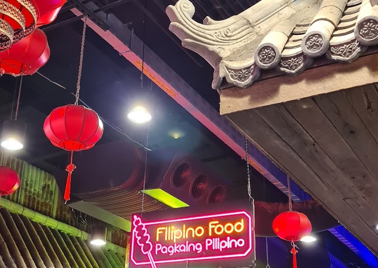 The pink Filipino Food neon sign hanging over the stall in 8 Street, Harbour Town